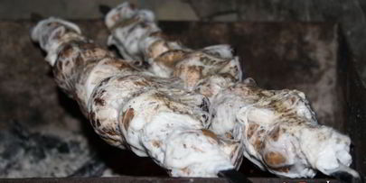 луговые шампиньоны в жировой сетке на мангале