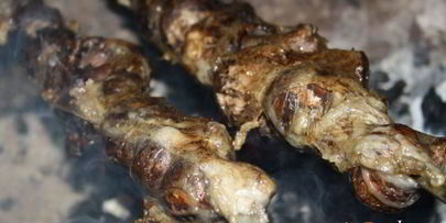 луговые шампиньоны в жировой сетке на мангале