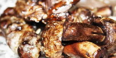 луговые шампиньоны в жировой сетке на мангале