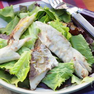 Копченая рыба на листьях салата