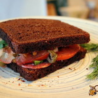 Сендвич из ржаного хлеба с салями и помидором